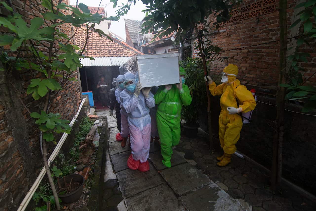 Health workers carry a coffin of a COVID-19 victim in Jakarta