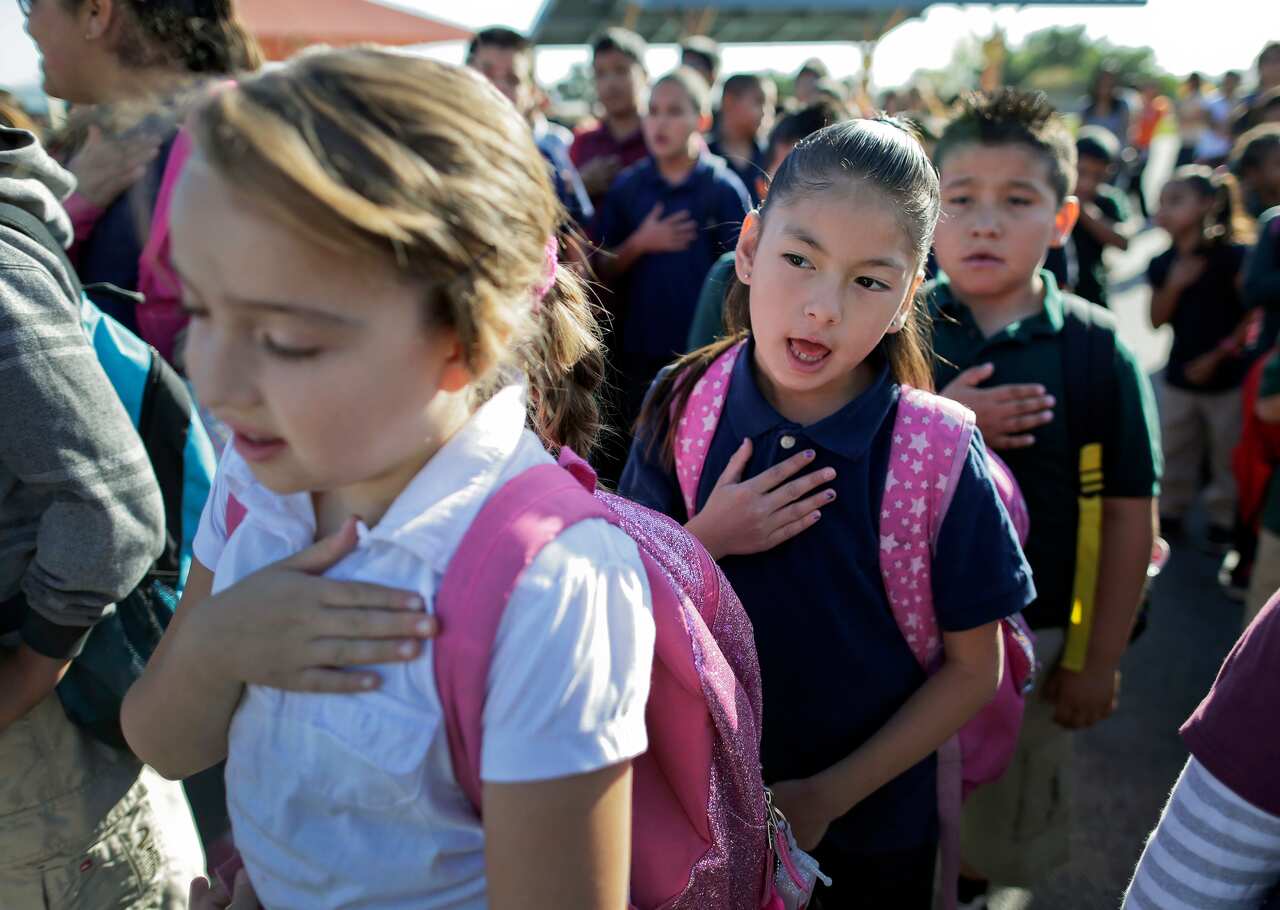 US students say the pledge of allegiance before the start of school.