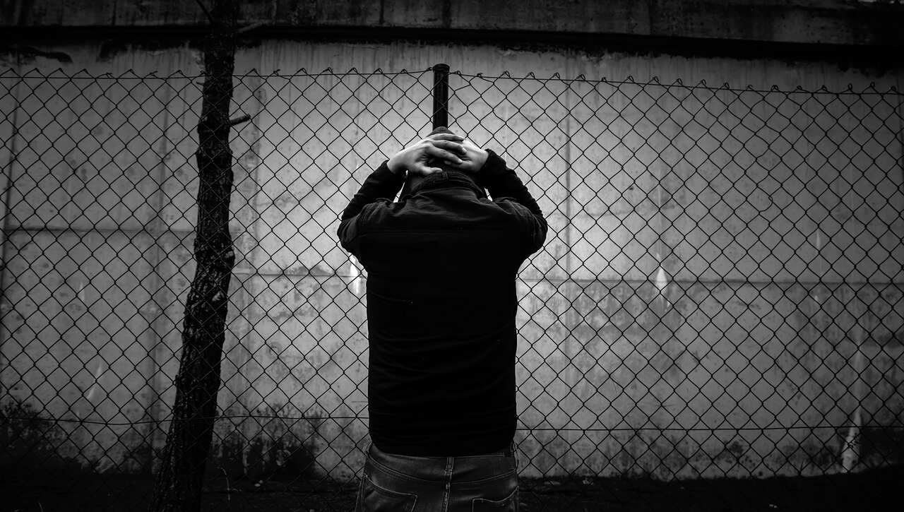 Man behind wire fence