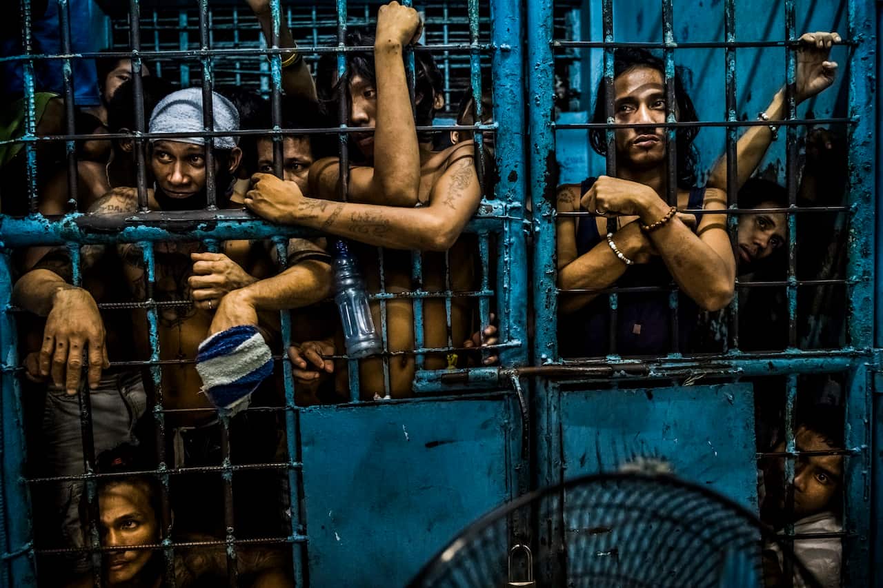 "They Are Slaughtering Us Like Animals" shows inmates watching as drug suspects are processed inside a police station in Manila, Philippines.