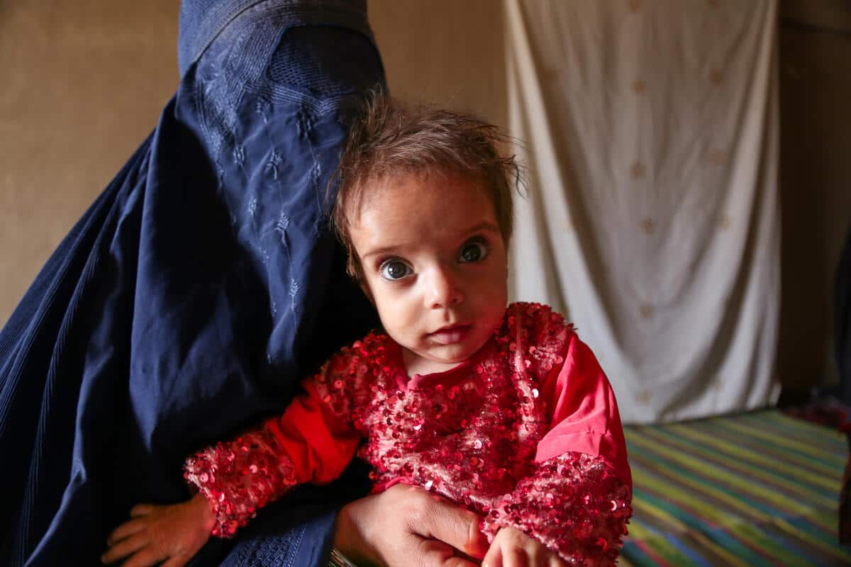 Afghan mother Fatima holding her 18-month-old daughter Ara.