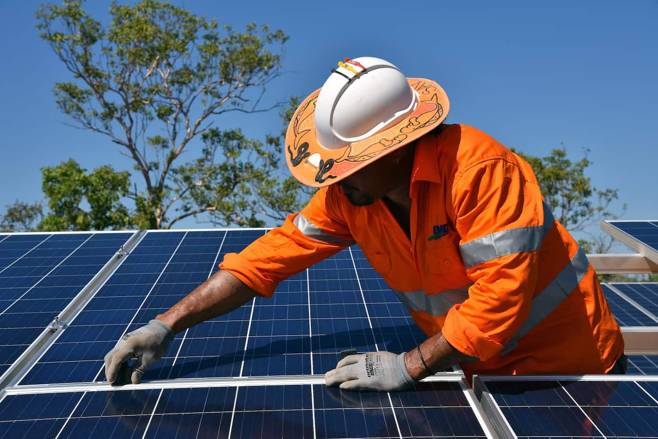 Workers install solar panels at a plant in the Nothern Territory. (AAP Image/Lucy Hughes Jones) 