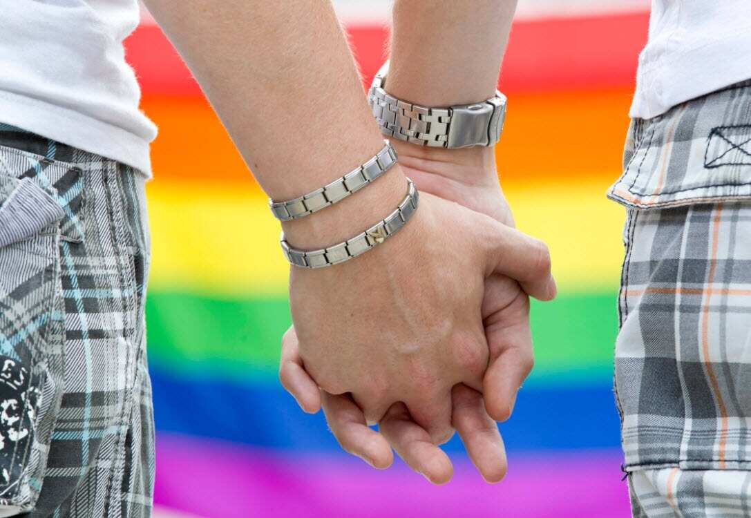 Two homosexual men holding hands.