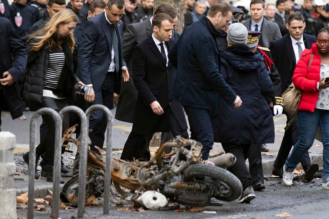 French President Emmanuel Macron assesses the damages of the 'Yellow Vests' protest a day earlier.