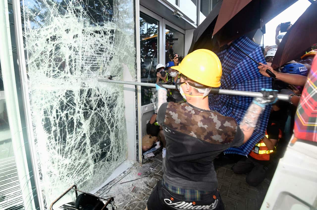 Protesters opposing Hong Kong's now-suspended extradition bill shatter glass to get inside the city's legislature building