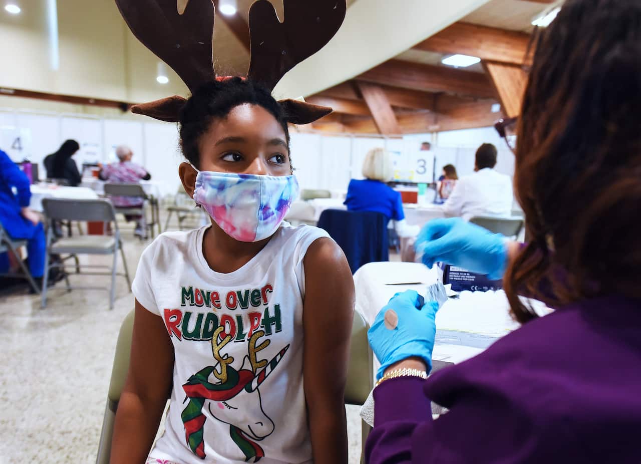 A health worker prepares to vaccinate a girl at the Sanford Civic Center in the US. 