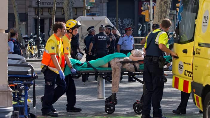 Mossos d'Esquadra Police officers and emergency service workers move an injured after a van crashes into pedestrians in Las Ramblas