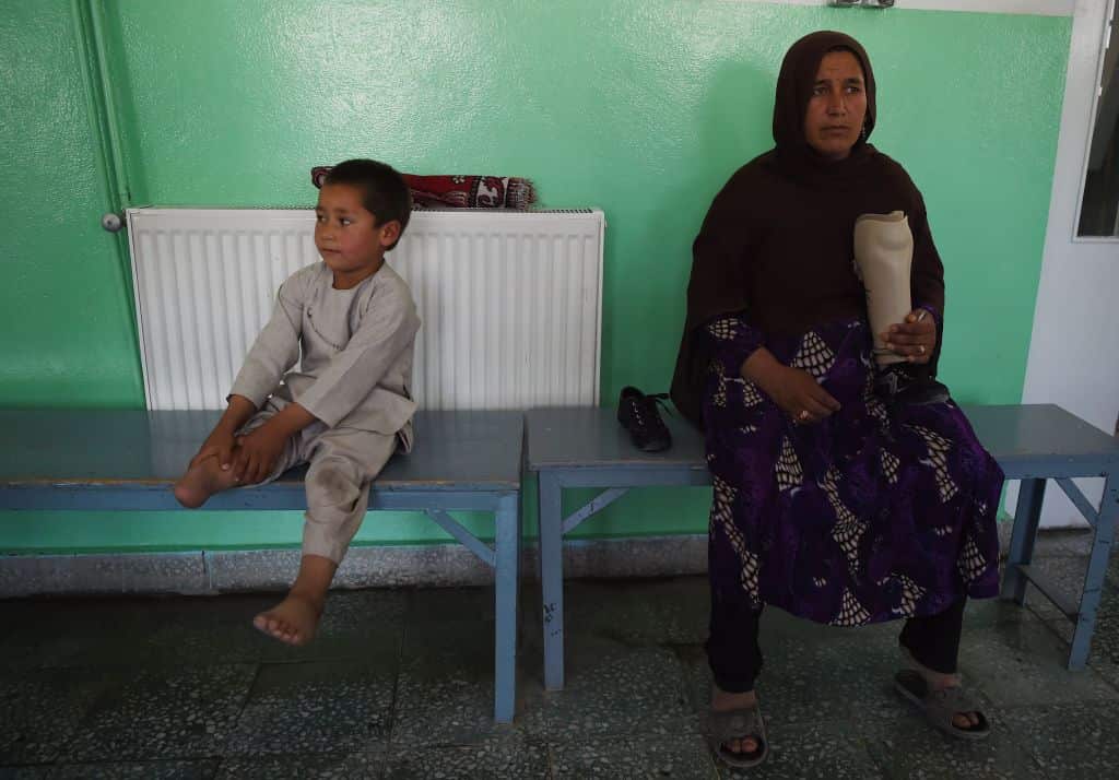 Ahmad sits on a bench next to his mother, 42-year-old Bibi Saera Raisa.