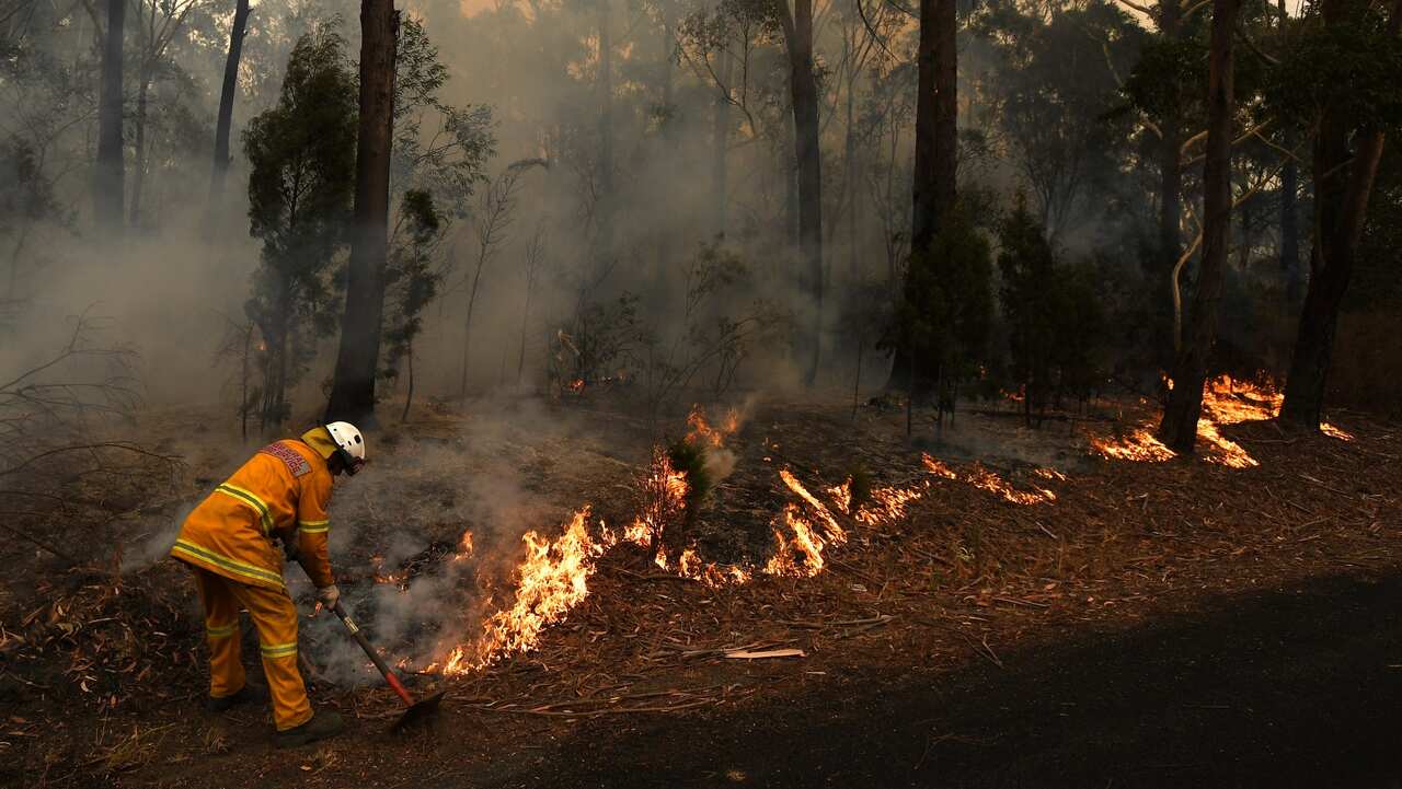 Firefighters contain a small bushfire which closed the Princes Highway south of Ulladulla, 5 January 2020. 