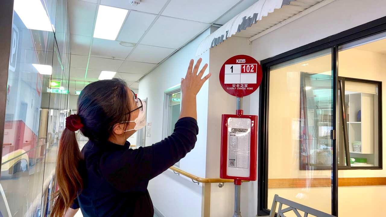 CEO of the Elderly Chinese Home, Minerva Lau, puts the finishing touches on the mocked-up bus stop.