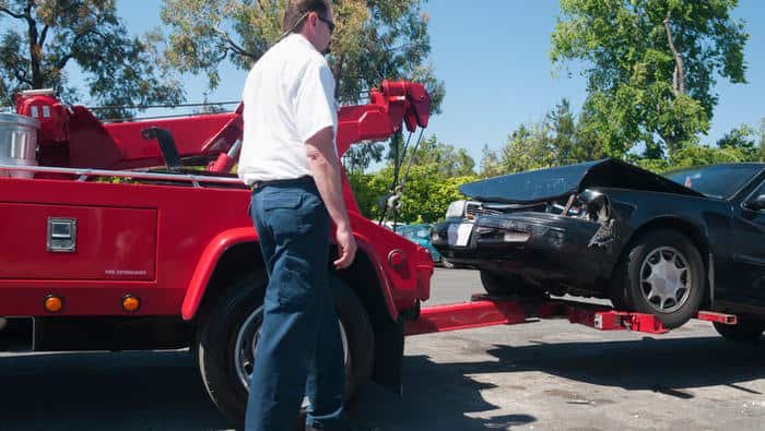 Tow Truck Driver Lifting a Wrecked Car
