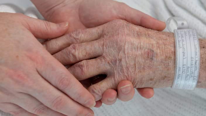 A nurse holds the hand of an elderly patient wearing a hospital identification band at Liverpool Hospital, Sydney on Tuesday, June 11, 2013.  (AAP Image/Dan Himbrechts) NO ARCHIVING