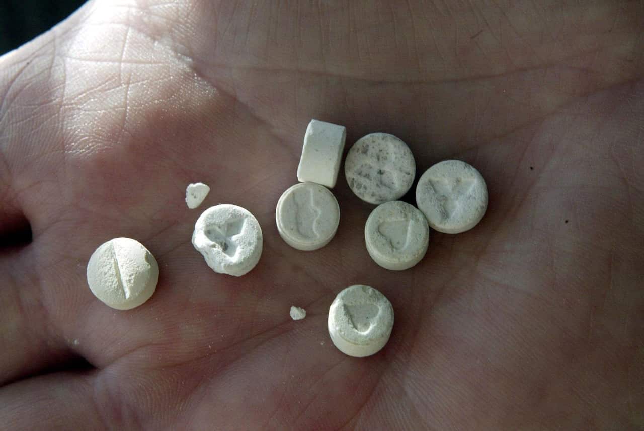 File photo of a person holding MDMA tablets.
