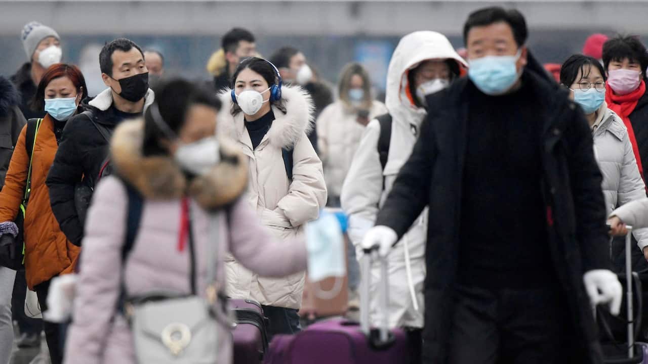People outside Beijing station wear face masks.