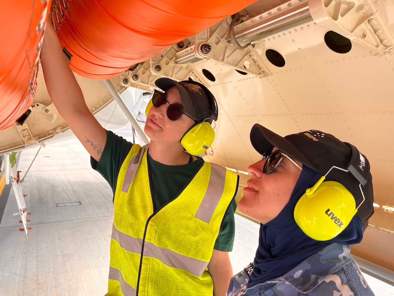 Flying Officer Ayah Khalid (right) in the weapons bay of the P-8A Poseidon