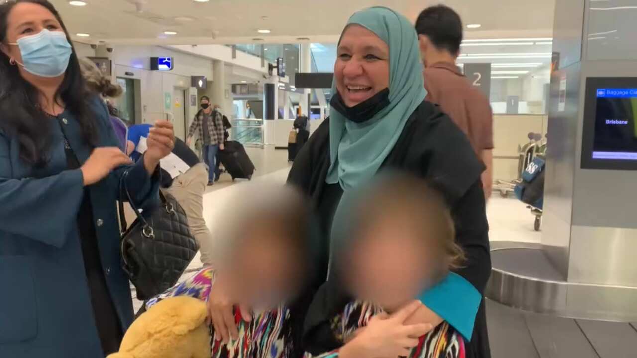 Mahboba Rawi with two of the orphans at the airport.