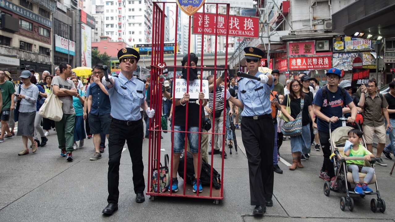 Pro-democracy activists dressed as mainland Chinese policemen take part in a march against a proposed extradition law in Hong Kong.