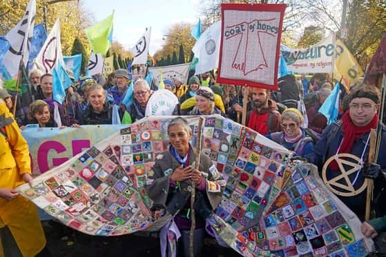 Melanie Nazareth wears the coat of hopes as she arrives with fellow pilgrims at Glasgow Green to raise awareness of the climate crisis