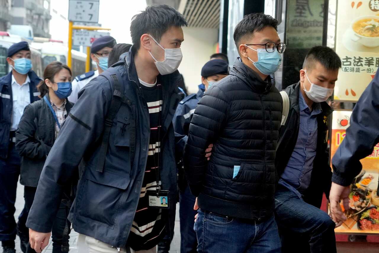 Editor of Stand News Patrick Lam, center, is arrested by police officers