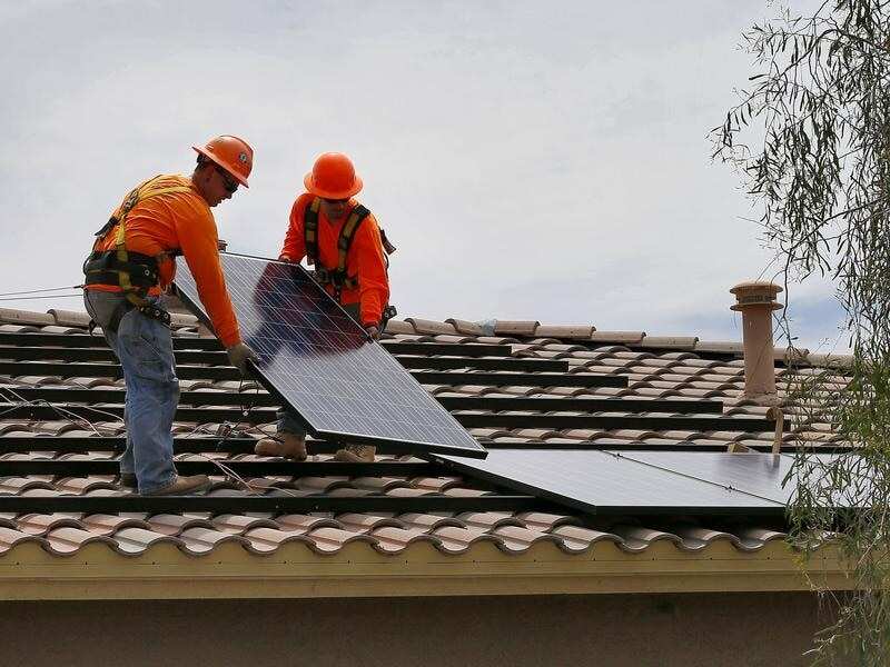 Electricians install a solar panel