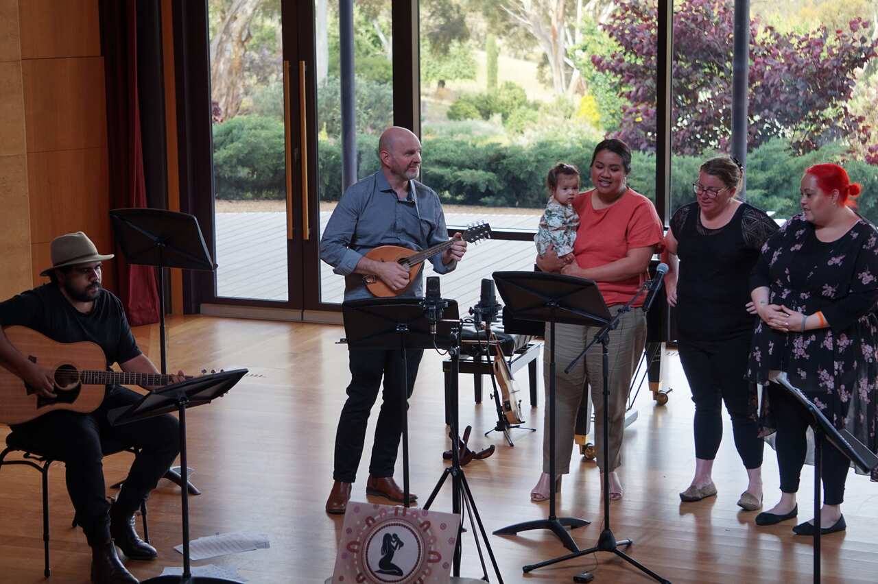 Daeya Possingham, far right and other carers or parents of First Nation children sing a lullaby the group created with the support of musicians.