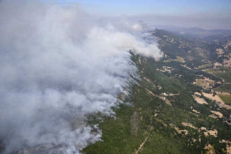 Smoke rises as a wildfire burns in the hills east of Napa, Calif., Monday, Oct. 9, 2017.