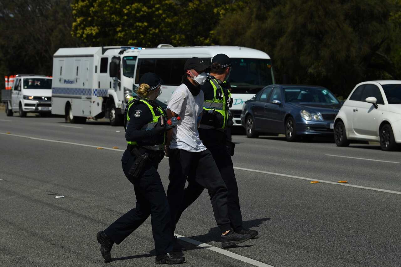 Victoria Police detain a protester near Elwood Beach.                                              