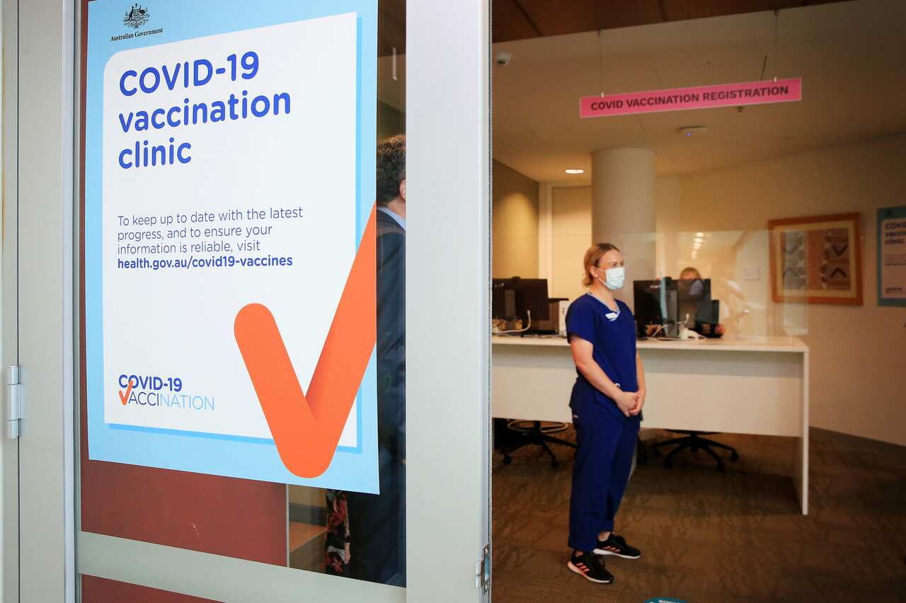 A COVID-19 Vaccination Clinic sign is seen as nurse Grace Gibney waits to receive one of the first Pfizer coronavirus vaccines at Austin Health in Melbourne