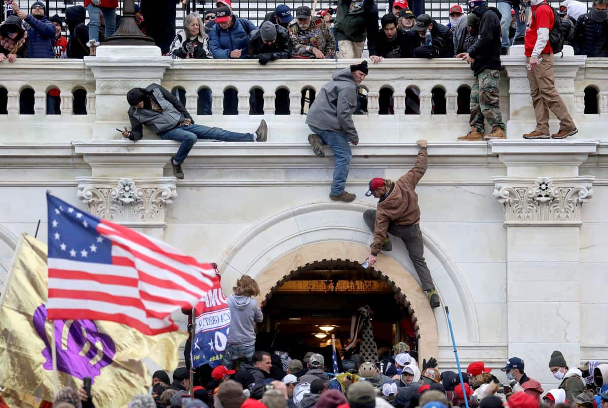A mob of supporters of US President Donald Trump fight with members of law enforcement as they storm the U.S. Capitol Building in Washington DC.