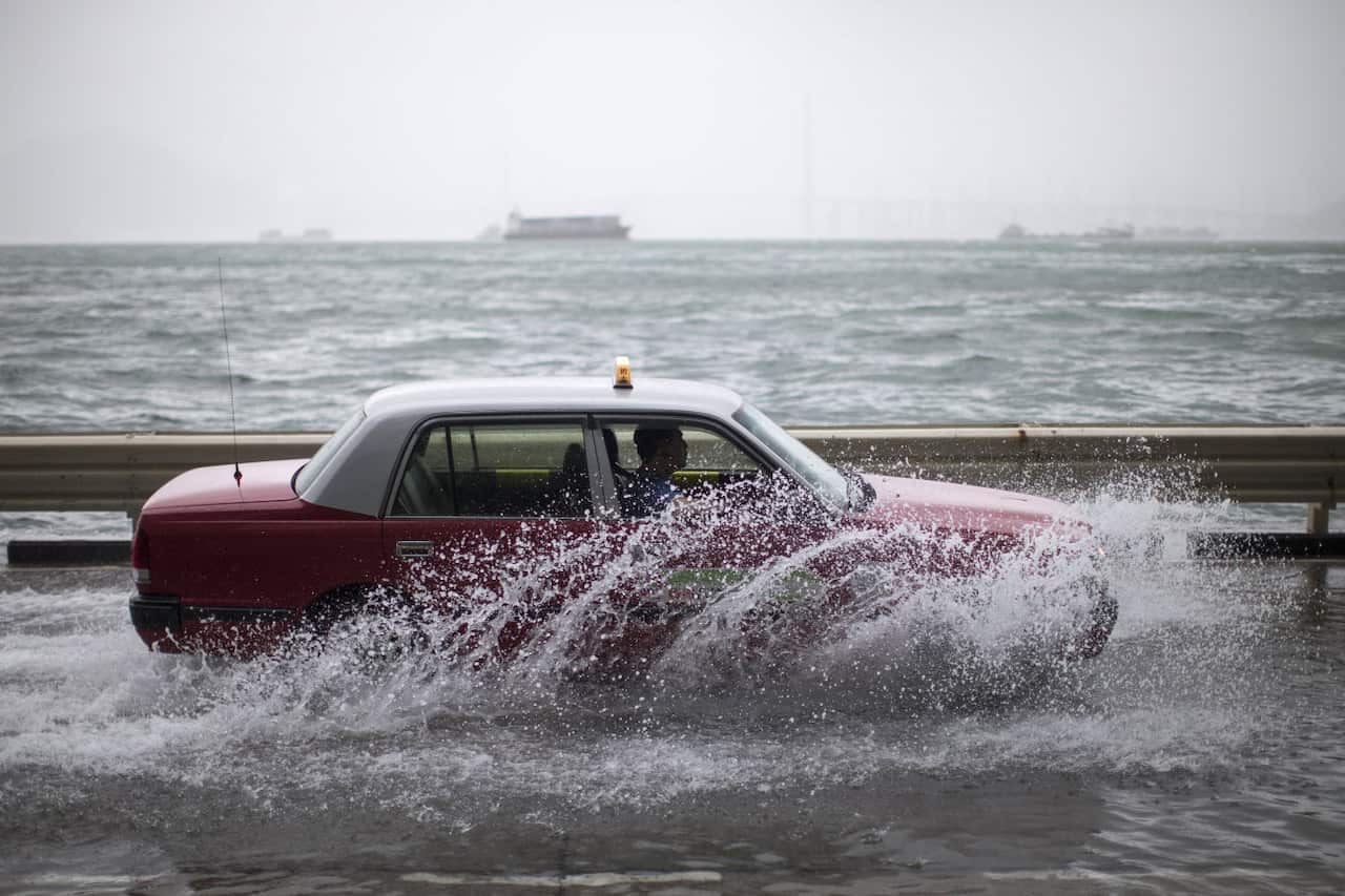 A taxi drives on a flooded street as typhoon Hato passes by in Hong Kong
