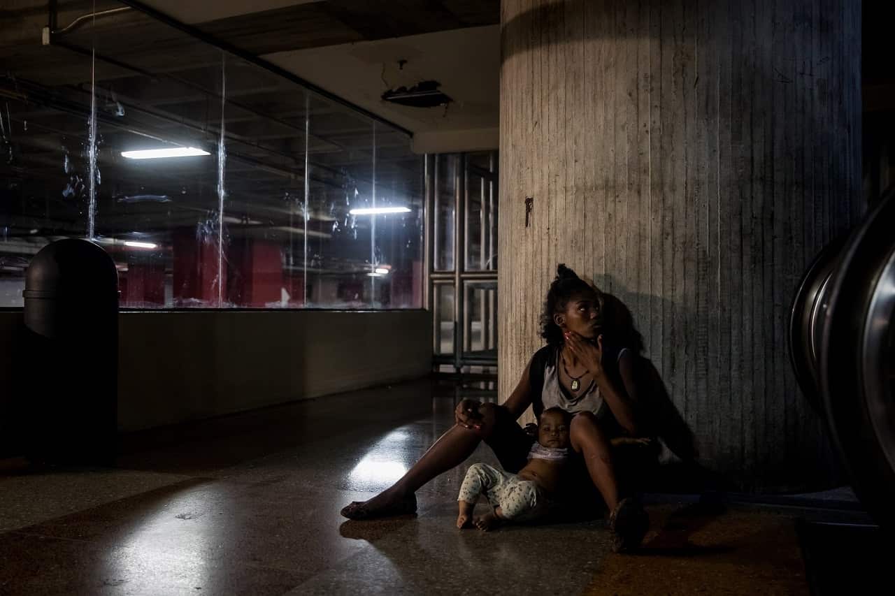 A young mother and child in a Venezuela parking lot.