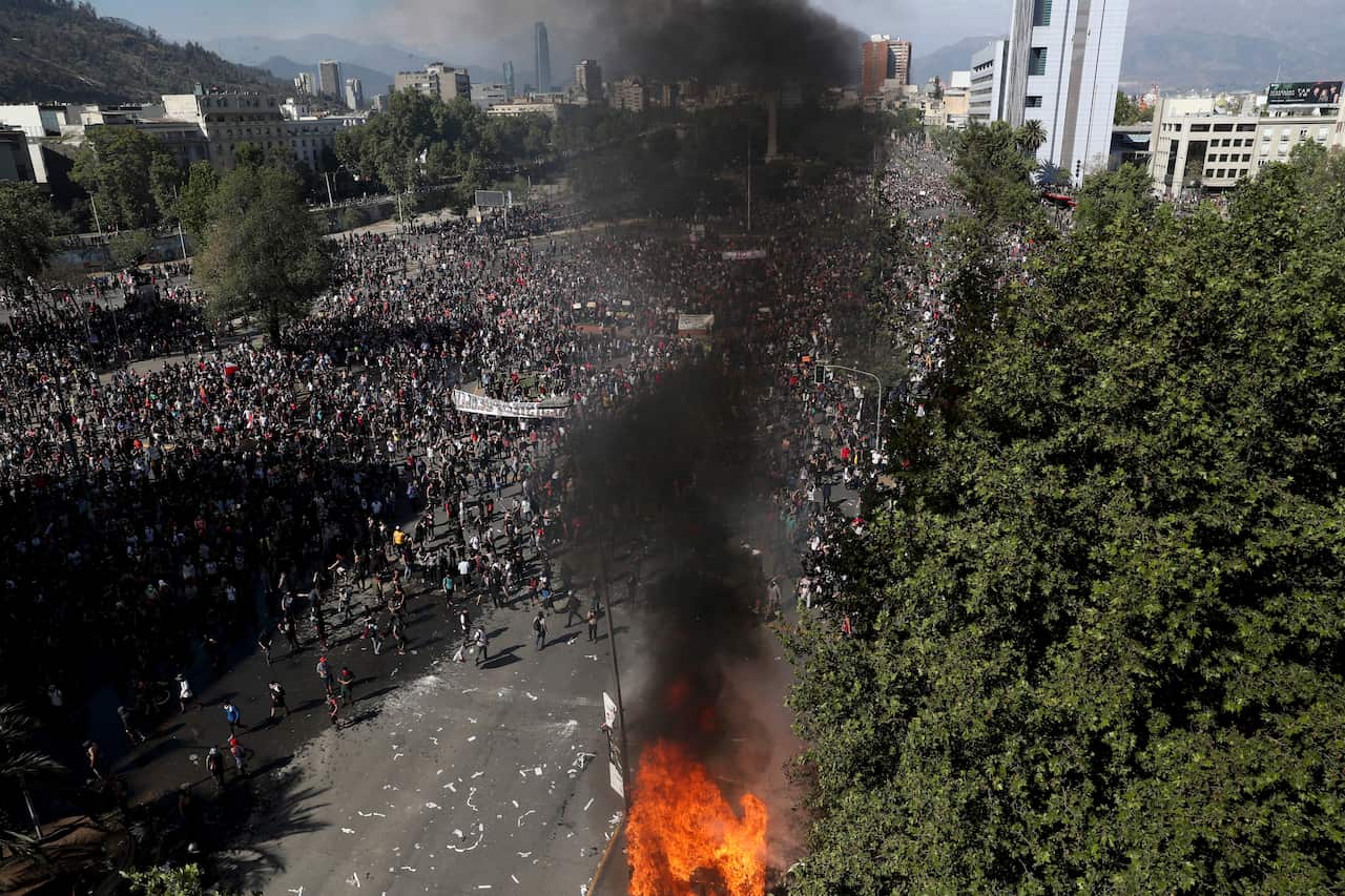 Anti-government protesters take part in a ongoing demonstrations triggered by an increase in subway fares in Santiago, Chile, 21 October.