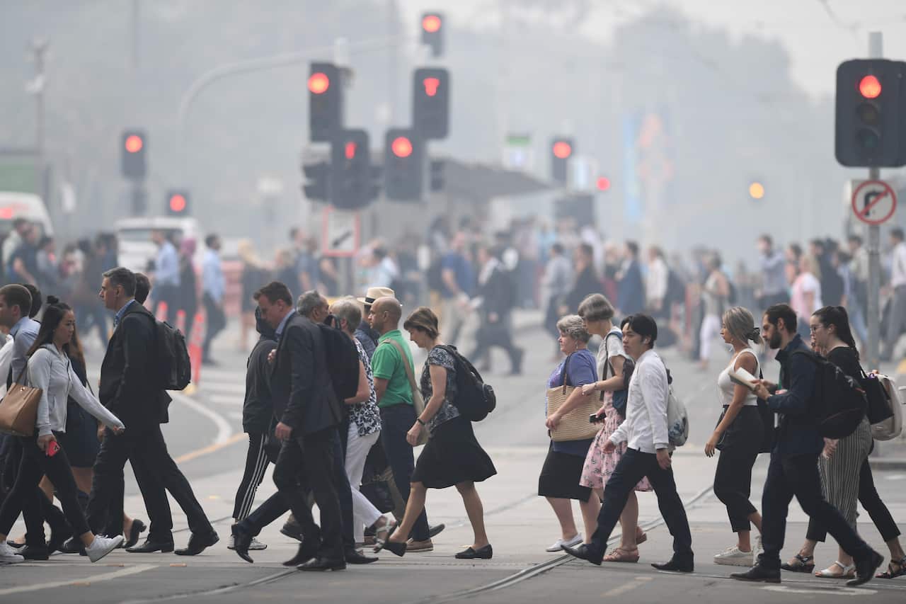Morning commuters are seen through smoke haze from bushfires in Melbourne.