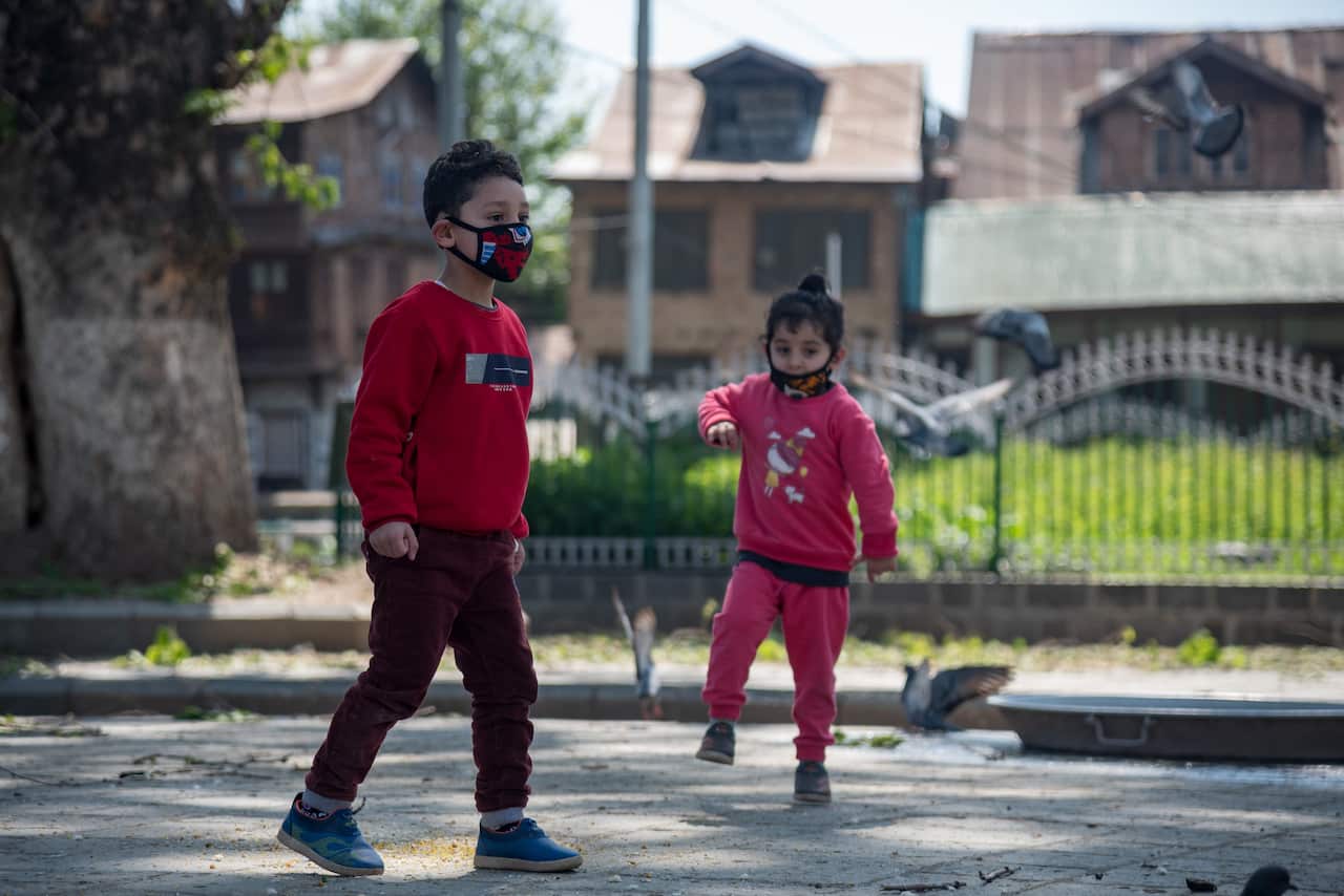 Children wearing face masks play during a one day curfew to curb the spread of COVID-19 in Srinagar.