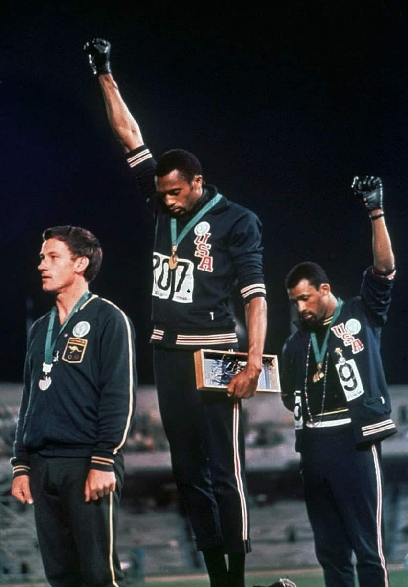 Tommie Smith (centre) and John Carlos raise their gloved fists on the podium after the 200-metre run event at the 1968 Olympics.