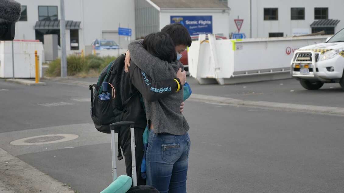 A couple embrace after being reunited at Hobart airport on Wednesday.