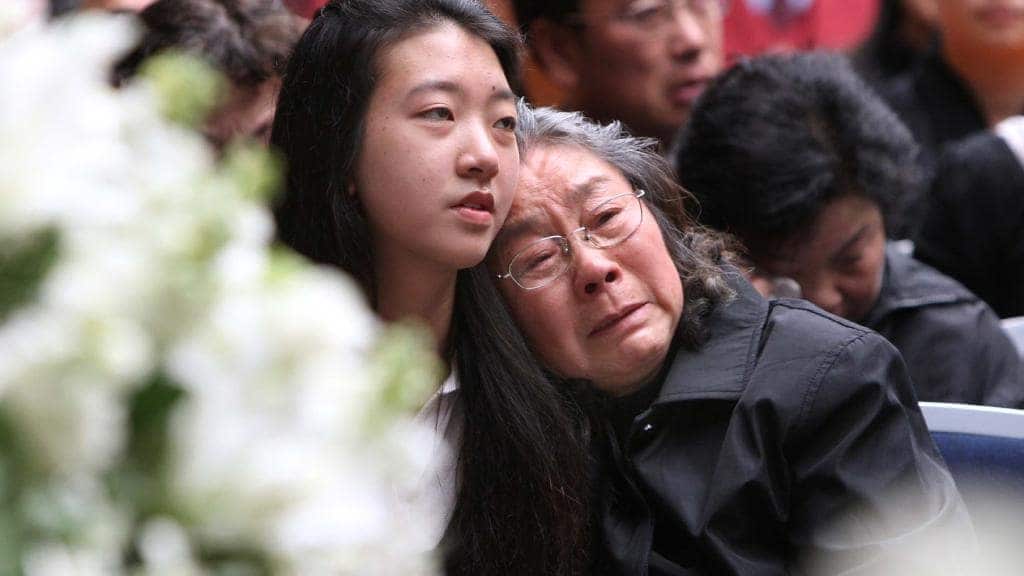 Brenda Lin with her grandmother Zhu Fenqin at funeral service for her parents, brothers and aunt.