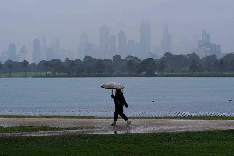 A person walks in isolation as heavy rain begins to fall in Melbourne, Wednesday, April 29, 2020.