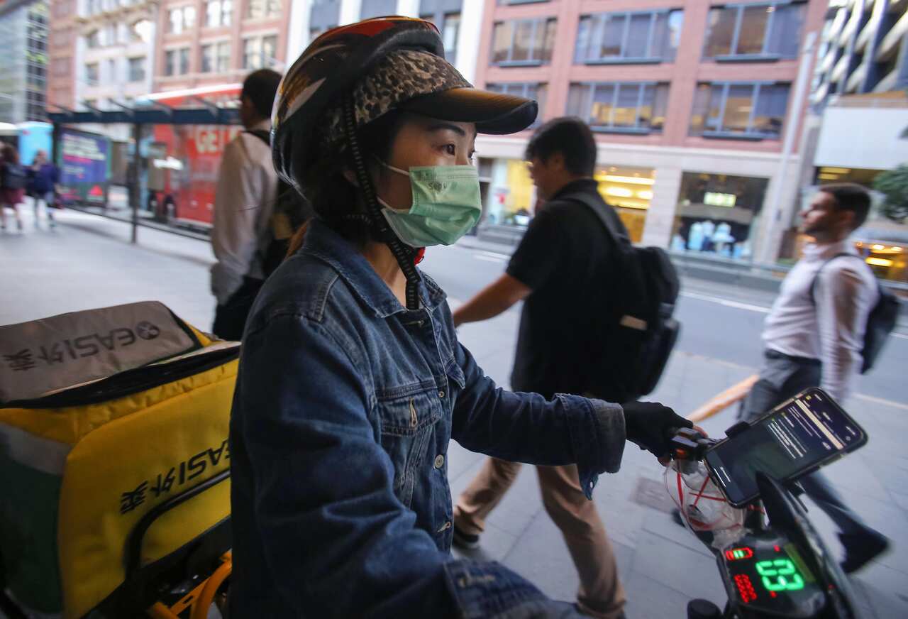 A food delivery rider wears a face mask in the CBD of Sydney.