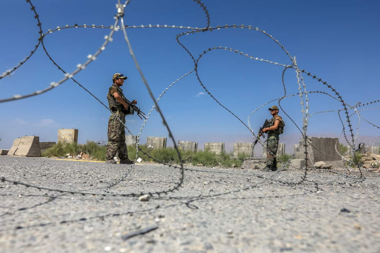 An Afghan National Army soldier stands guard at the Bagram Air Base gate.