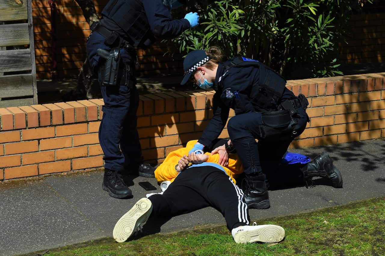 Victoria Police arrest a protester at Elwood Beach, following an anti-lockdown protest in Melbourne.