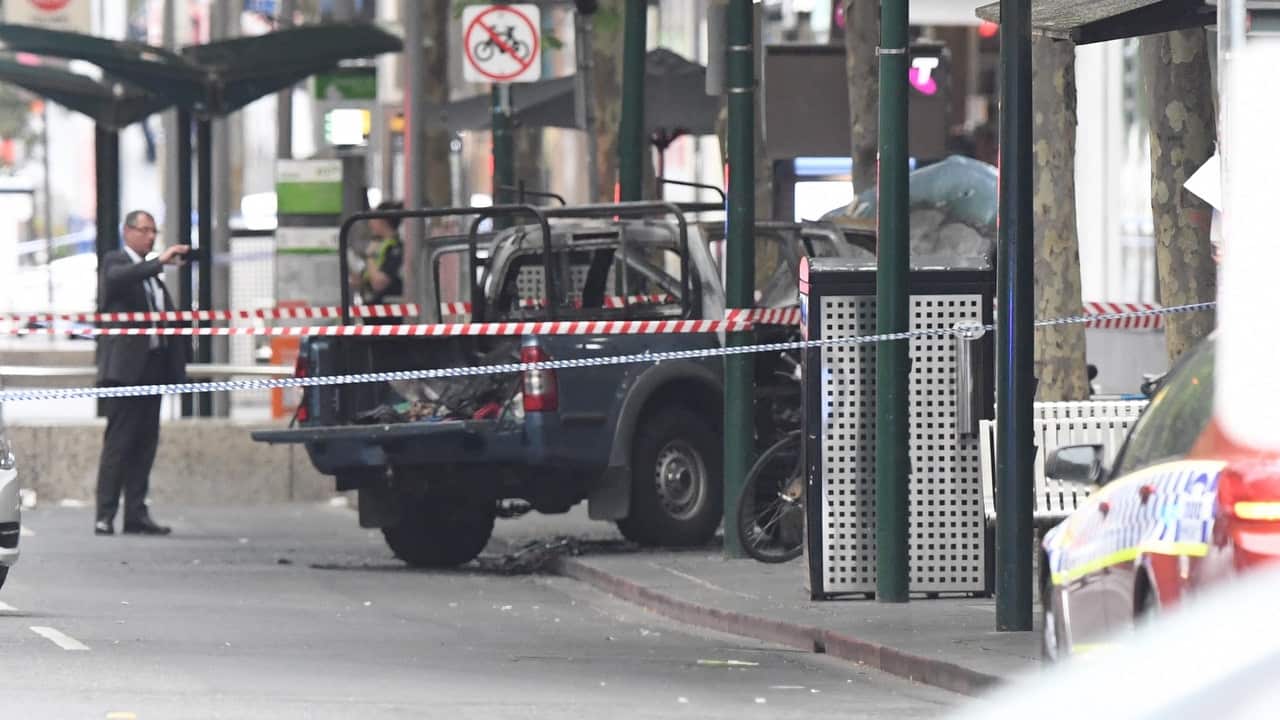 A burnt out vehicle is seen on Bourke Street in Melbourne.