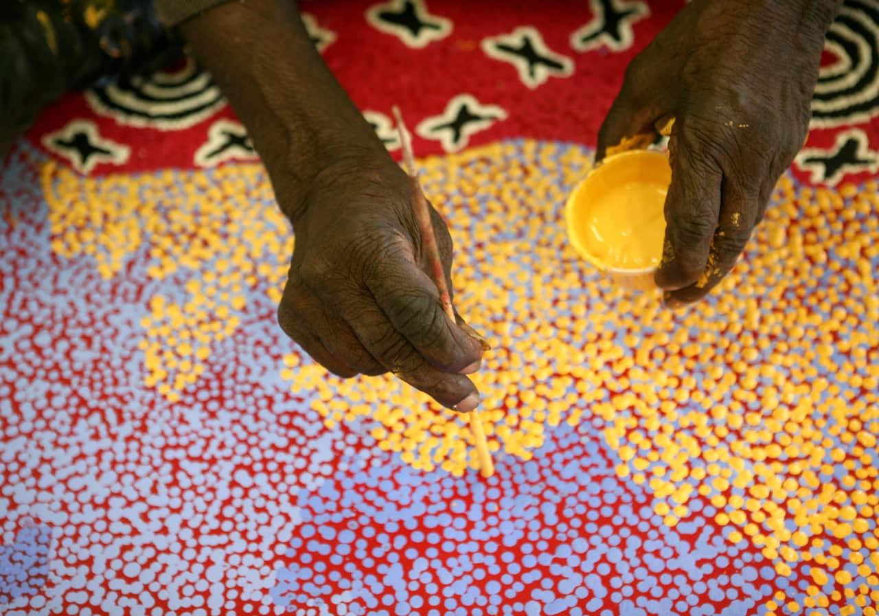 Paddy Stewart works on a dot painting