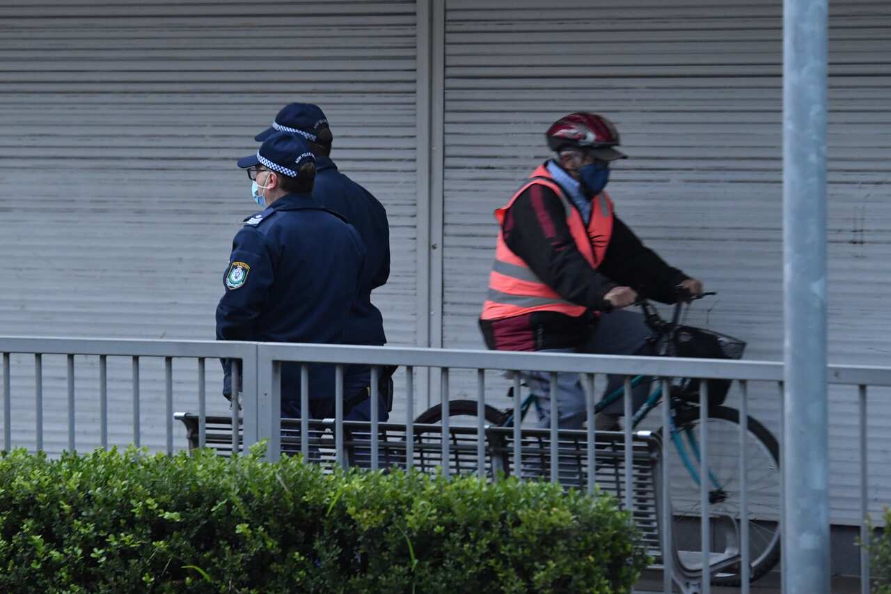 Police are seen walking in the southwestern suburb of Fairfield in Sydney on Friday, 9 July, 2021. 
