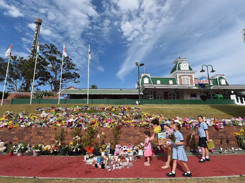 A family lays flowers outside the Dreamworld theme park