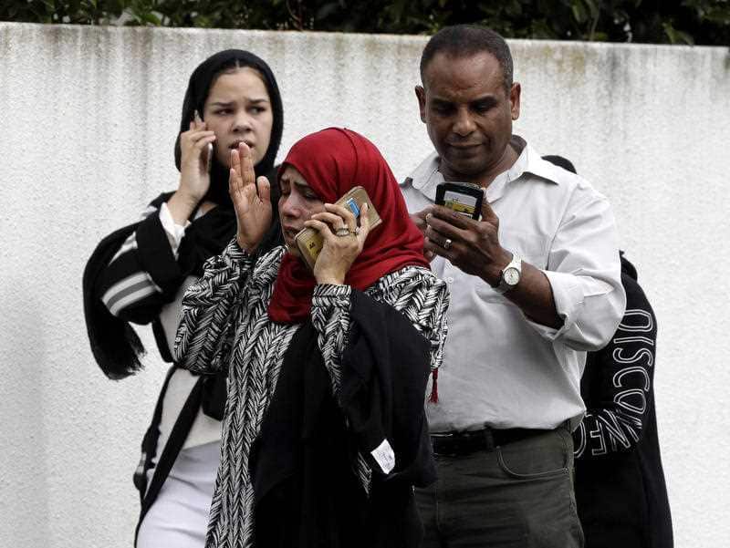 People wait outside a mosque in central Christchurch following the shooting.