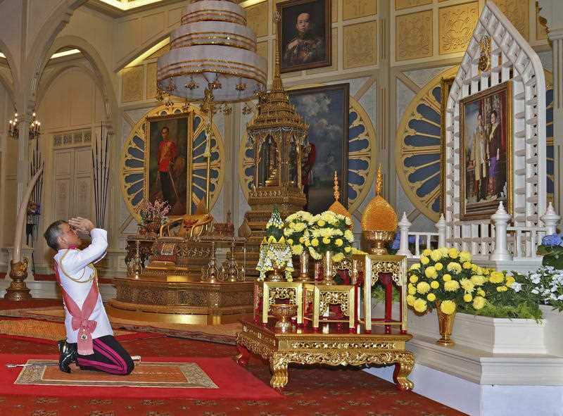 Thailand 's new king Maha Vajiralongkorn Bodindradebayavarangkun pays his respects to a portrait of the late Thai King Bhumibol Adulyadej 