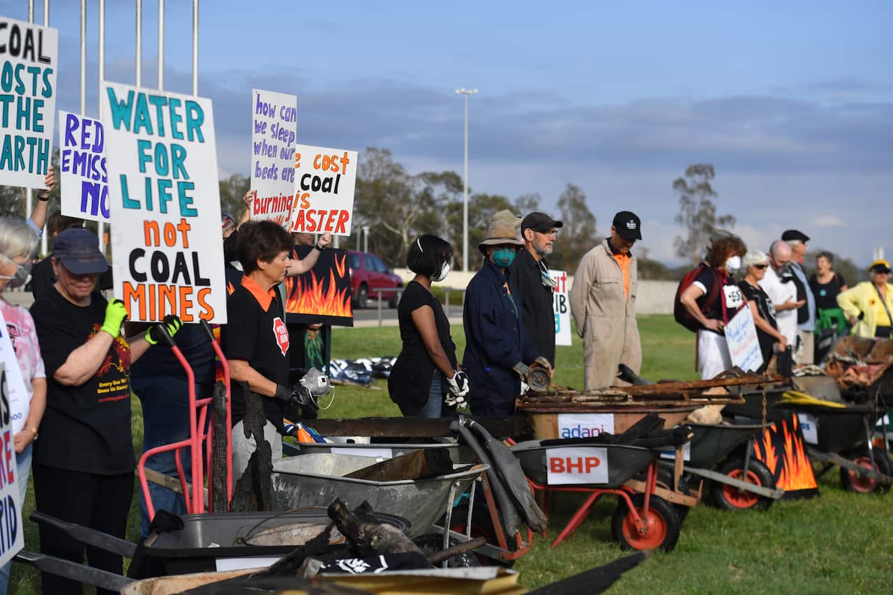 Bushfire survivors use burnt debris from the recent bushfires to create a symbolic trail of destruction outside Parliament House.