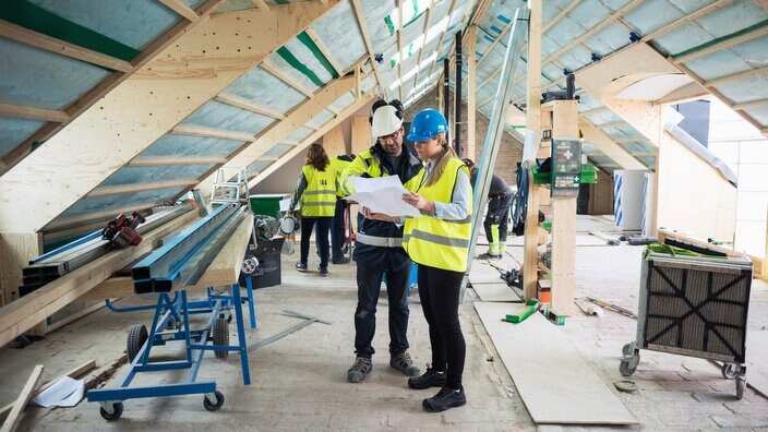 Construction managers planning while standing in messy site
