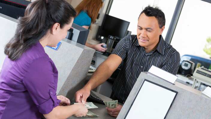 Customer at the bank getting money from teller
